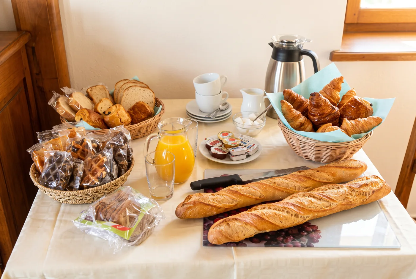Petit déjeuner complet de la soirée étape : croissants, jus d'orange, café et baguettes fraîches